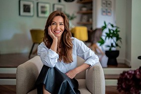 Portrait of smiling woman sitting in armchair