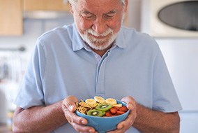 A smiling senior man about to eat a salad