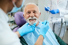 A smiling senior man looking at his dentist