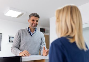 a patient speaking with a front desk staff