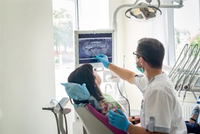 a dentist showing a patient her X-rays