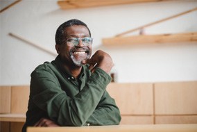 a man with glasses smiling